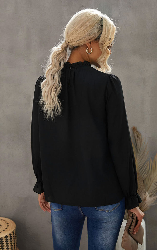 Blonde woman wearing the Sophia Frill Sleeve mock neck blouse from Stella by Stacia